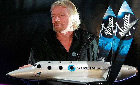 Virgin Galactic CEO, Richard Branson, holding a spacecraft model. From the Daily Mail.